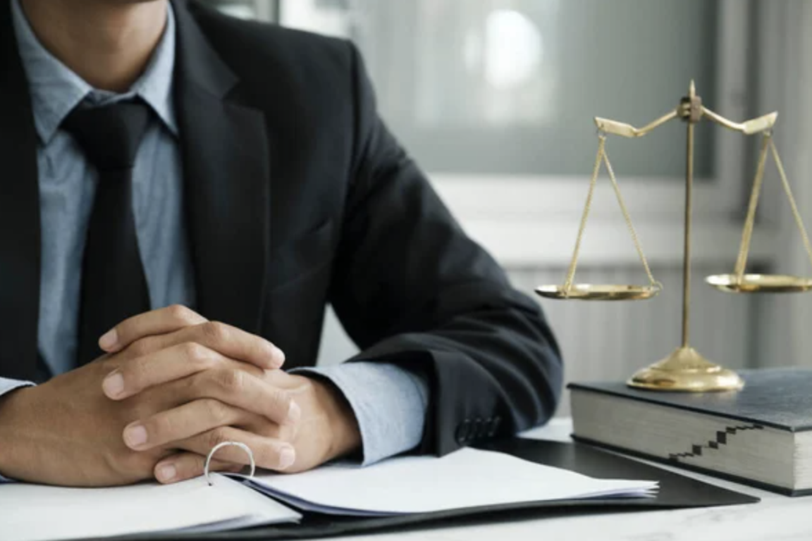 NYC Criminal Lawyer seating behind desk showing trusting gestures to his client